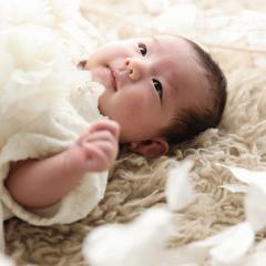 ドレスを着た赤ちゃんが寝ている写真
