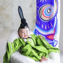 こいのぼりを背景に男の子が笑っている写真