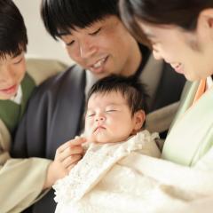 寝ている赤ちゃんを家族で見守る
