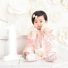手を広げて座る１歳の子