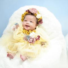 黄色いドレスを着た赤ちゃんの写真