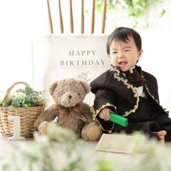 タキシードを着て座る男の子の写真