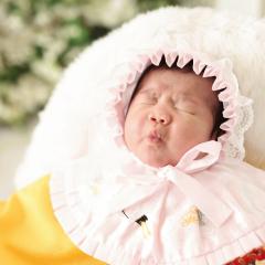 眠たい顔をする赤ちゃんの写真