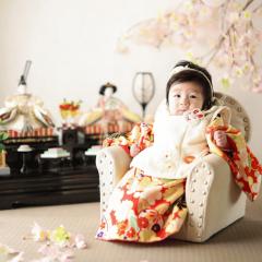 ひな人形と一緒に座る女の子の写真