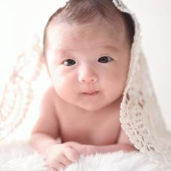 はだかんぼでうつぶせをするあかちゃん