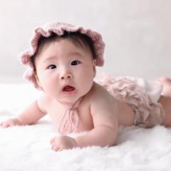 うつ伏せでニット帽をかぶっている赤ちゃん