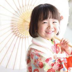 七五三の着物を着て傘を持つおんなのこ