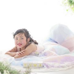 レインボーのドレスを着て寝転ぶおんなのこ