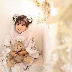 七五三の被布を着てくまのぬいぐるみを抱えるおんなのこ
