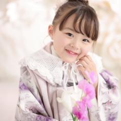 七五三の着物を着て花を持つおんなのこ