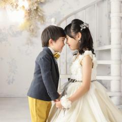 ドレスとタキシードを着ておでこをくっつけたきょうだい
