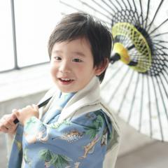 被布を着て傘を持つおとこのこ