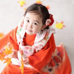 もみじを持って座るおんなのこ