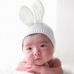 うさぎの耳をつけてうつ伏せをするあかちゃん