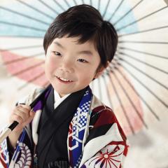 傘を持って微笑む男の子