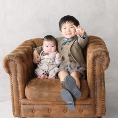 仲良く兄弟で椅子に座る写真