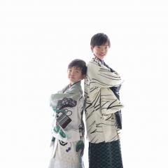 袴を着て背中合わせで立つきょうだい