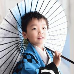 青い袴を着て傘をさす男の子