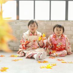 もみじを持って座る姉妹