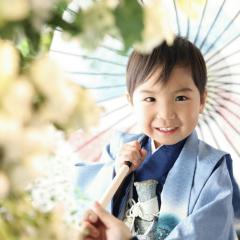 青い袴を着て傘をさすおとこのこ