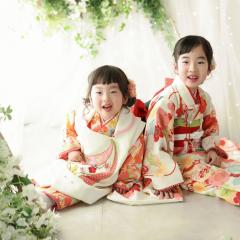 お着物を着て背中合わせに座る姉妹