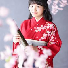 赤い着物を着て卒業写真を撮る女の子