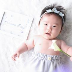 お花を片手に嬉しそうな赤ちゃん