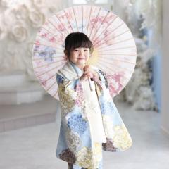 水色の着物を着て傘をさす女の子